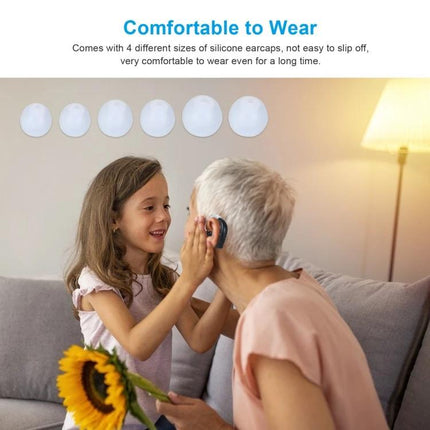 Rechargeable Hearing Aid for Seniors with Adjustable Amplification and Charging Base being fitted by granddaughter to grandmother on couch, comfortable silicone earpieces