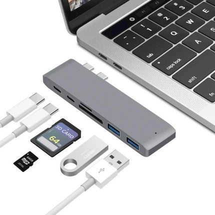 USB-C Multi-Port Docking Station with HDMI and Card Reader shown beside laptop with SD cards, USB drives and cables for file transfer and external display