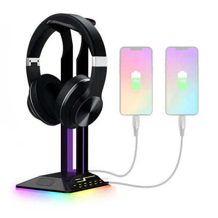 Headset Stand With RGB Lighting And Dual USB Charging Ports on desk with headphones and two phones charging