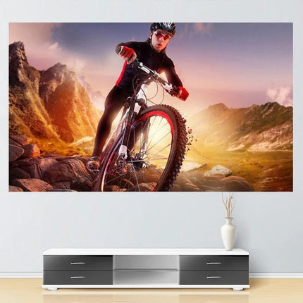 Portable Folding Projection Screen for Home Use showing a mountain biking scene projected above a modern TV stand