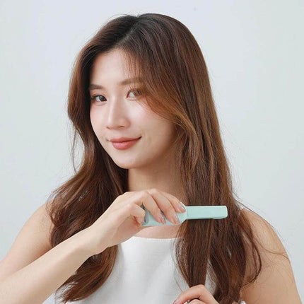 Dual-Use Mini Electric Hair Straightener, Cherry Pink being used by woman for quick touch-up with compact USB-powered design
