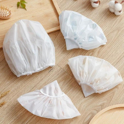 Comfortable Shower Hat for Women's Daily Bathing Protection - white PEVA waterproof disposable shower caps arranged on wooden surface
