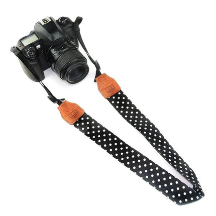 Retro Style Camera Shoulder Strap for Everyday Use with black polka dot fabric and brown faux leather accents attached to DSLR