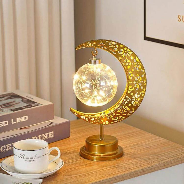 Moon Lamp With Wrought Iron Frame For Ambient Lighting on bedside table casting warm glow