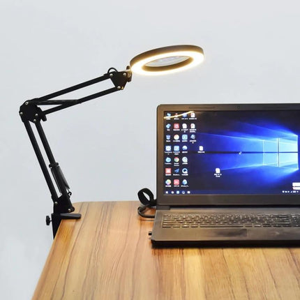 Versatile Clip Magnifying Lamp for Home Reading and Crafts clipped to desk illuminating laptop and crafting workspace with 5x 105mm lens