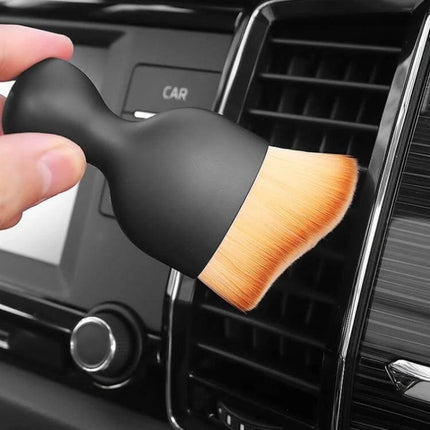 Car Air Conditioner Vent Cleaning Brush with Soft Synthetic Fibers being used to clean car AC vents without scratching surfaces