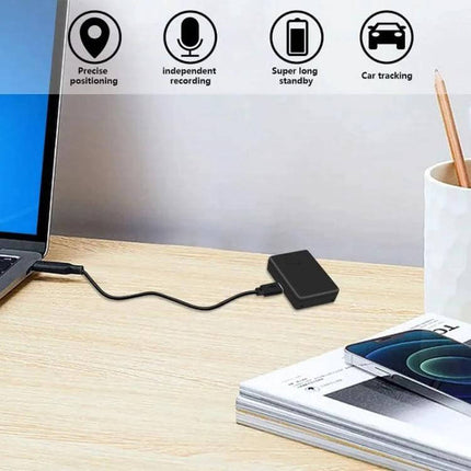 Portable Voice-Activated Anti-Theft Locator for Security Use on desk near laptop, demonstrating GSM tracking, voice detection and car tracking features