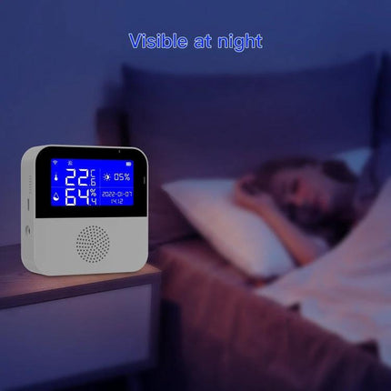 Tuya WiFi Temperature and Humidity Sensor for Home Monitoring on bedside table with blue night display showing temp and humidity