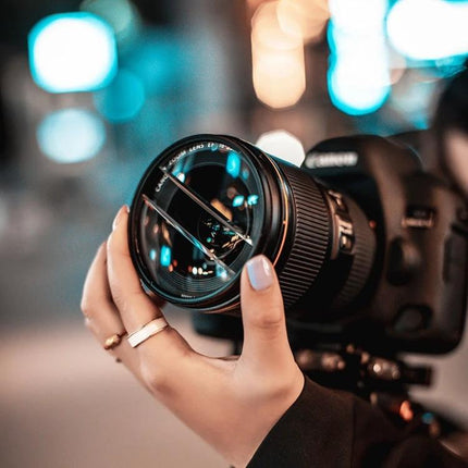Double Half Moon Foreground Blur Filter for Photography held on a camera lens creating soft foreground bokeh and clear central focus