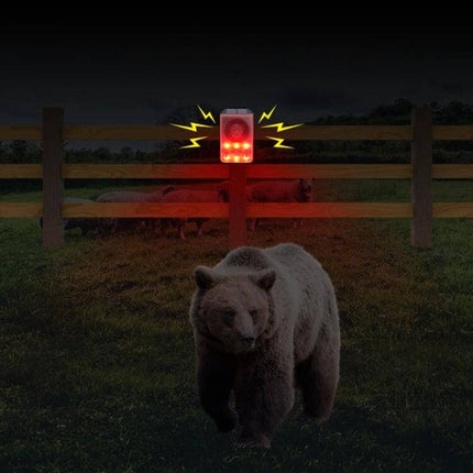 Solar Animal Repeller with Sound and Light for Outdoor Use mounted on fence emitting red light and sound to deter bears and pests