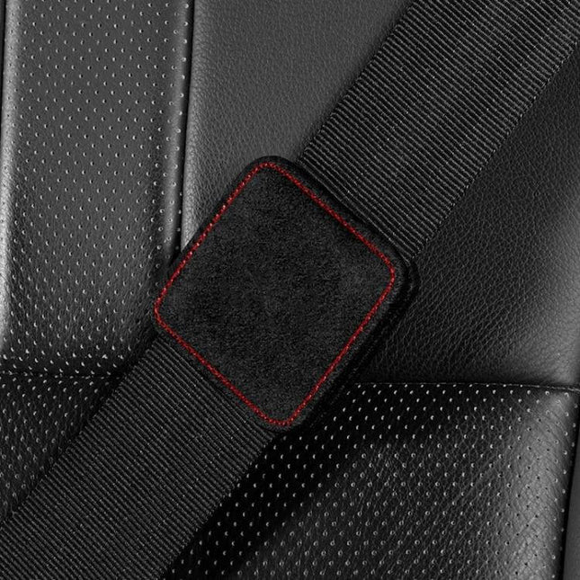 Car Seat Belt Limiter Elastic Adjuster Magnetic Fixation on black car seat showing suede pad with red stitching for comfortable belt position