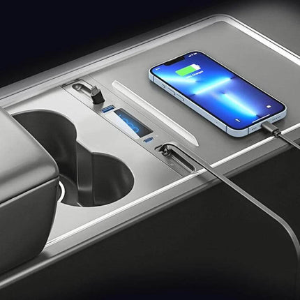 Compact Interior USB C Docking Hub For Car Charging installed in Tesla Model 3/Model Y center console showing two retractable USB-C cables and charging phone