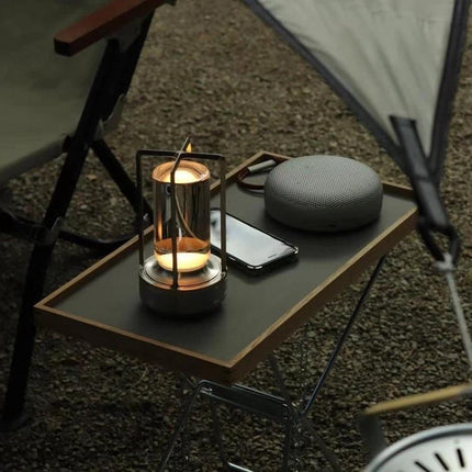 A Lamp That Lights Up Your Home and Camping Nights Easily on a portable camping table beside phone and speaker