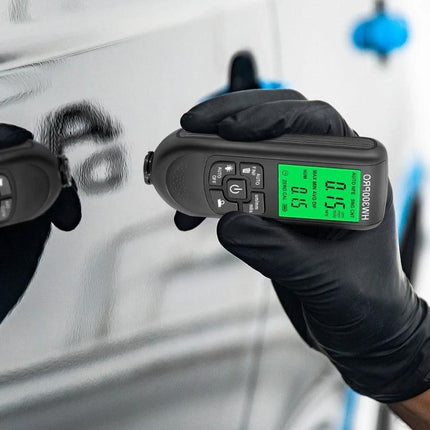 Coating Thickness Gauge for Paint and Industrial Use handheld meter measuring car paint thickness with gloved hand