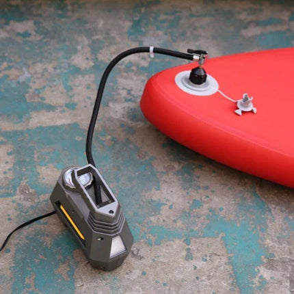 Surfing Paddle Board Air Valve Adapter For Easy Inflation Black Orange connected to pump inflating red SUP on concrete