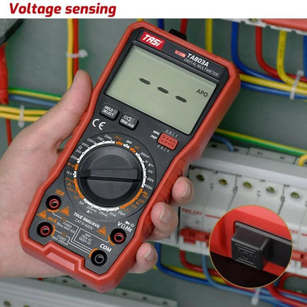 TASI Digital Multimeter for Household Electrical Testing in hand measuring voltage on home wiring panel