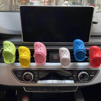 Cute Shoes Shape Car Air Vent Ornament With Aromatherapy clipped in colorful shoe-shaped diffusers on a car vent to freshen cabin