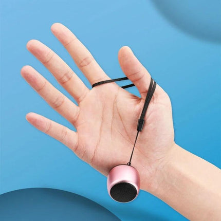 Compact Bluetooth Speaker For Travel And Daily Listening small pink travel speaker on hand with wrist strap, pocket-friendly