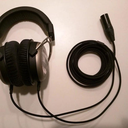 Versatile Balanced Headphone Cable with Adapters and Connectors shown coiled beside high‑end over‑ear headphones with XLR and dual 3.5mm ends