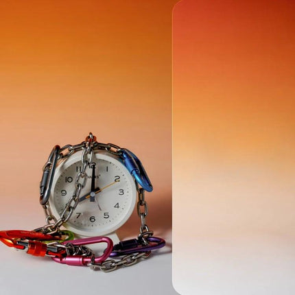 Gradient Background Paper for Portrait Photography, 106x144cm showing clock wrapped in colorful carabiner chain on warm orange gradient backdrop