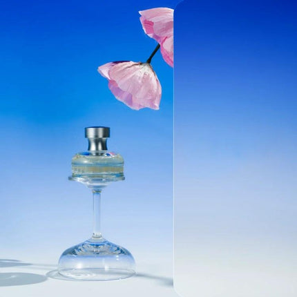 Gradient Background Paper for Portrait Photography, 106x144cm showcasing perfume on inverted glass with pink flower and smooth blue gradient backdrop