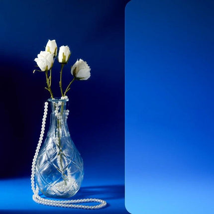 Gradient Background Paper for Portrait Photography, 106x144cm showing a glass vase with white roses and pearls on a smooth blue gradient surface