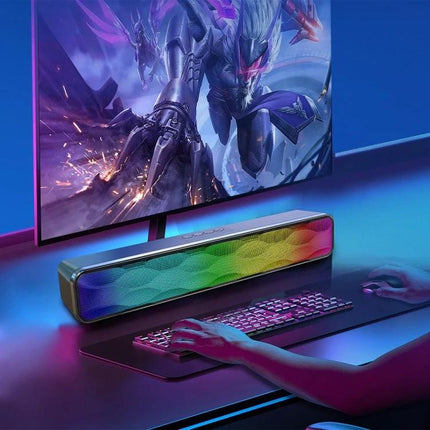 Compact Bluetooth Home Speaker For Everyday Listening with RGB front grille on gaming desk beside monitor and keyboard
