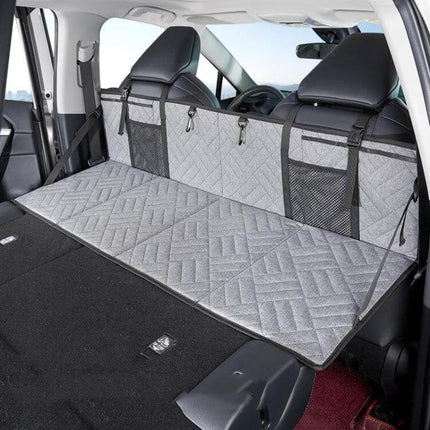 Car Camping Bed Folding Board For SUV Rear Row Gray Embossed shown set up flat in SUV rear with quilted gray surface and mesh storage pockets