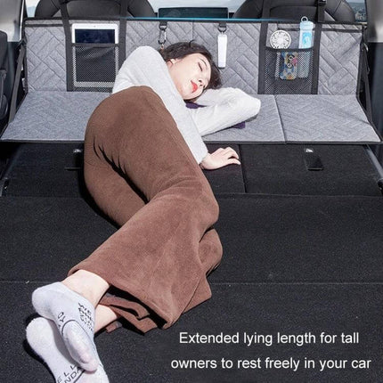 Car Camping Bed Folding Board For SUV Rear Row Gray Embossed - woman lying on extended rear SUV bed with quilted gray embossed fabric and storage pockets
