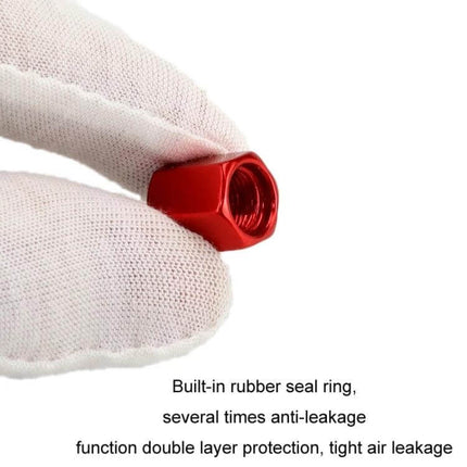Skull Metal Tire Valve Caps Set of 4 Universal Aluminum red anodized aluminum cap with built-in rubber seal shown held by gloved hand