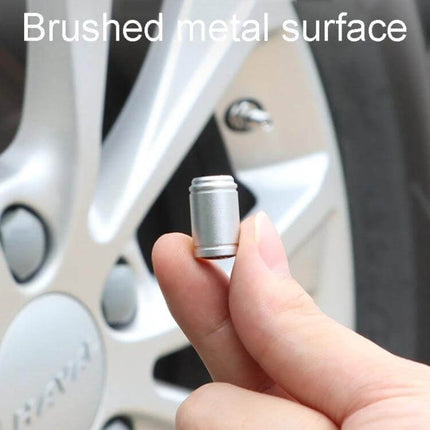 Aluminum Alloy Tire Valve Caps For Everyday Use Set Of 4 — brushed silver cap held near car wheel, protects valve stems from dust and moisture