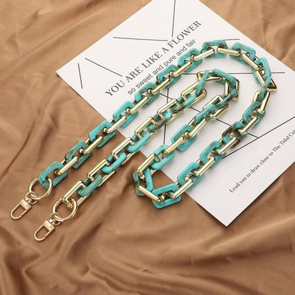 Retro Tortoiseshell Acrylic Phone Lanyard for Hands-Free Use turquoise-gold chained acrylic lanyard displayed on tan fabric and paper