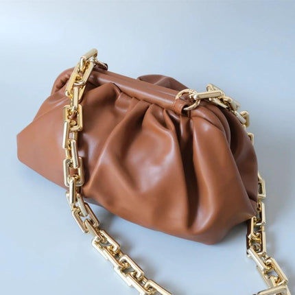 Retro Tortoiseshell Acrylic Phone Lanyard for Hands-Free Use worn crossbody with brown leather clutch and gold chain accent