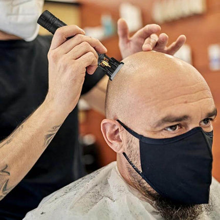 Electrical Haircut Pusher For Home Use With Buddha Head Design being used to shave a masked man’s head, close 0.1mm ultra-short tooth finish