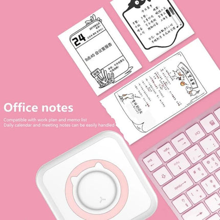 Mini Bluetooth Inkless Thermal Printer for Photos and Labels printing cute office notes and labels beside keyboard on pink desk