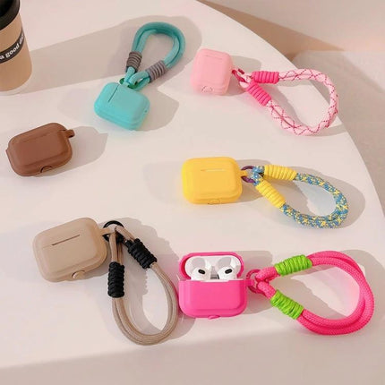 Protect Your AirPods During Daily Activities With Silicone Cover - colorful silicone AirPods cases with braided wrist straps on table