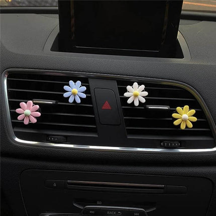 Colorful Daisy Car Decorative Air Vent Aromatherapy Clip Blue shown attached to car vent with pastel daisy clips freshening cabin