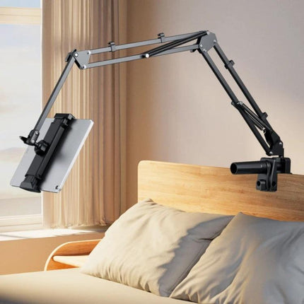 Universal Telescopic Stand for Cell Phones and Tablets mounted on bedside headboard holding a tablet at adjustable angles for hands-free viewing