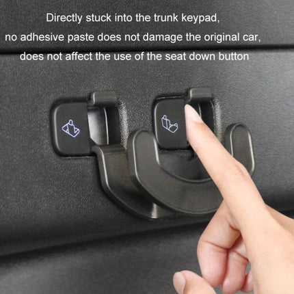 Tesla Model Y Trunk Seat Button Hook For Extra Hanging Space installed on trunk keypad showing finger pressing seat-down button and added hanging hook