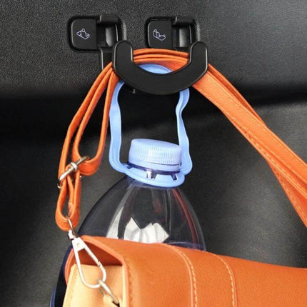 Tesla Model Y Trunk Seat Button Hook For Extra Hanging Space installed holding a purse and water bottle in trunk