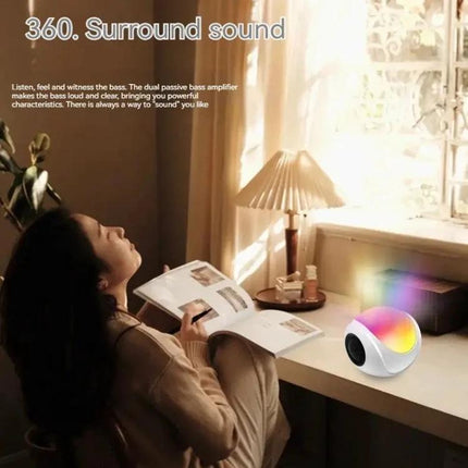 Portable Bluetooth Speaker Compact For Home And Travel Use on desk with woman reading, ambient light, 360 surround sound, 1200mAh battery
