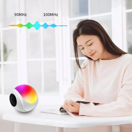 Portable Bluetooth Speaker Compact For Home And Travel Use shown on table with ambient light and woman reading near window 1200mAh