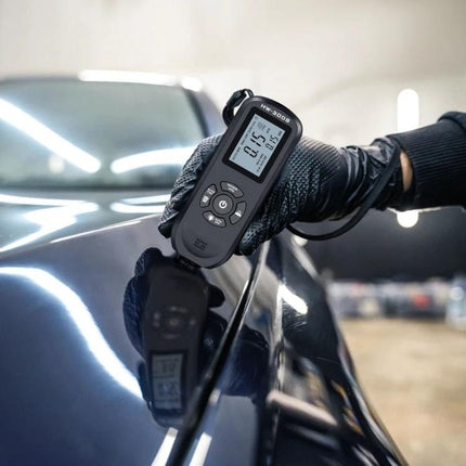 Coating Thickness Gauge for Precise Paint Measurement held on vehicle paint showing 0.75mm reading with probe and gloved hand