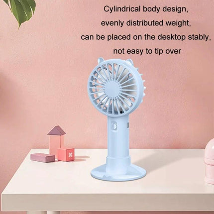 Portable Rechargeable Mini Handheld Fan with Phone Holder for Desktop Use shown in pastel blue on a desk, cylindrical stable design for hands-free cooling