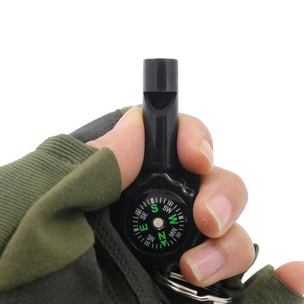 2 In 1 Whistle Compass For Outdoor Survival With Mountaineering Buckle handheld black whistle compass shown in gloved hand, nylon lanyard and buckle attached