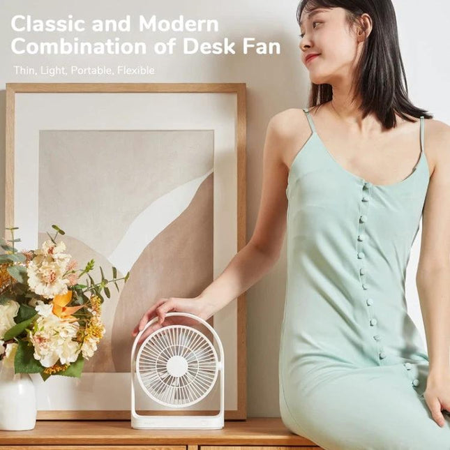 JisuLife Rechargeable Mini Fan for Portable Everyday Cooling shown on desk next to vase and woman in mint dress