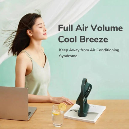 JisuLife Rechargeable Mini Fan for Portable Everyday Cooling shown on desk beside laptop and glass with breeze on woman's face