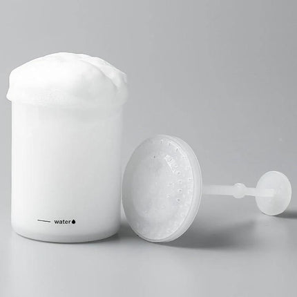 Portable Foaming Cup for Daily Skincare and Travel Use shown with rich foam, simple white travel foam maker cup and plunger