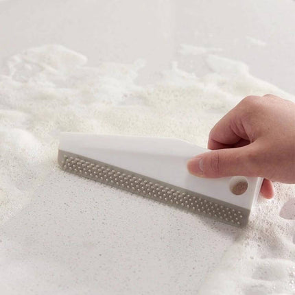 Kitchen Bathroom Countertop Scraper Dual Sided Cleaning used to lift soap scum and dried residue from a white countertop with ergonomic grip