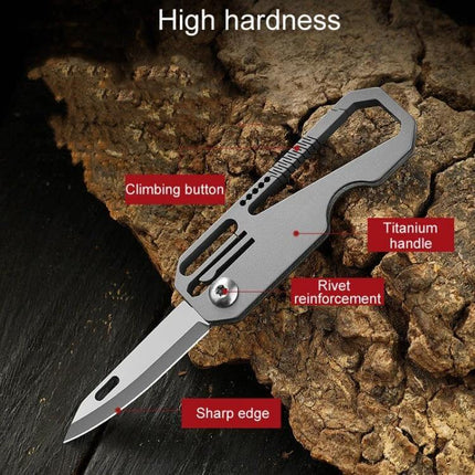 Titanium Keychain Folding Knife With Titanium Ring For Everyday Carry compact titanium handle folding blade on rock background